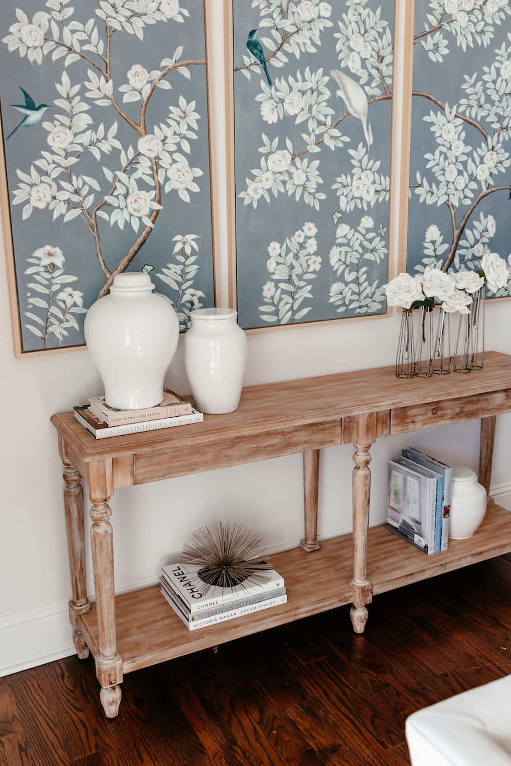 Living Room console styled with books and white ceramic vases