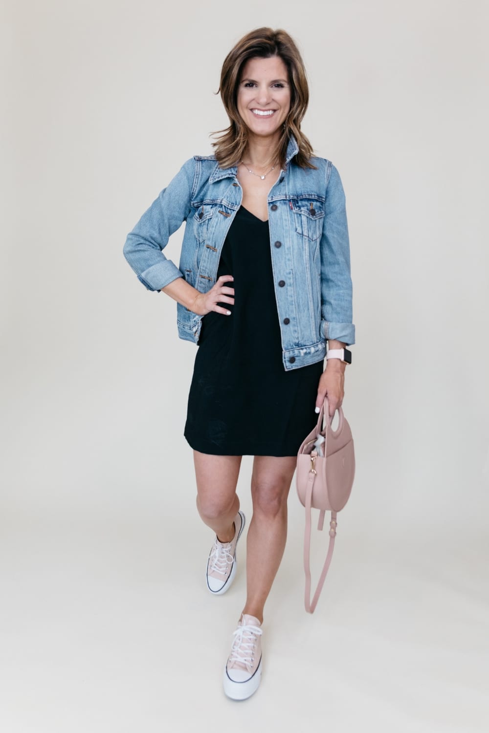 black dress with denim jacket and sneakers