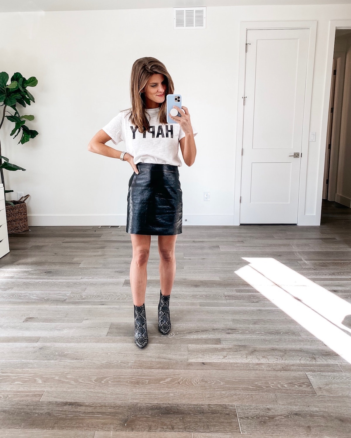 Brighton Keller wearing Leith faux leather skirt, happy tee and snakeskin booties