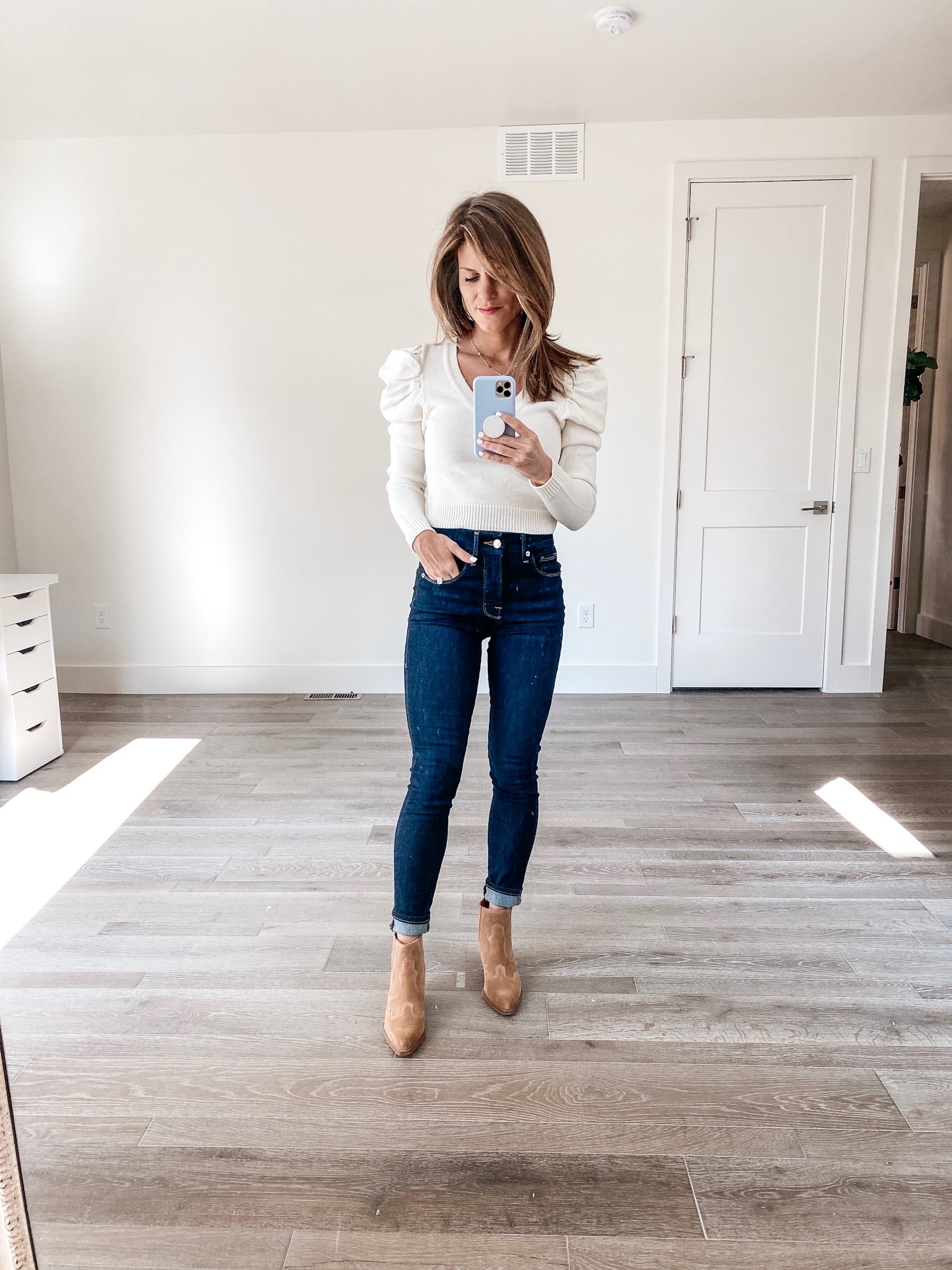 brighton keller wearing puff long sleeve top with button up jeans and tan booties