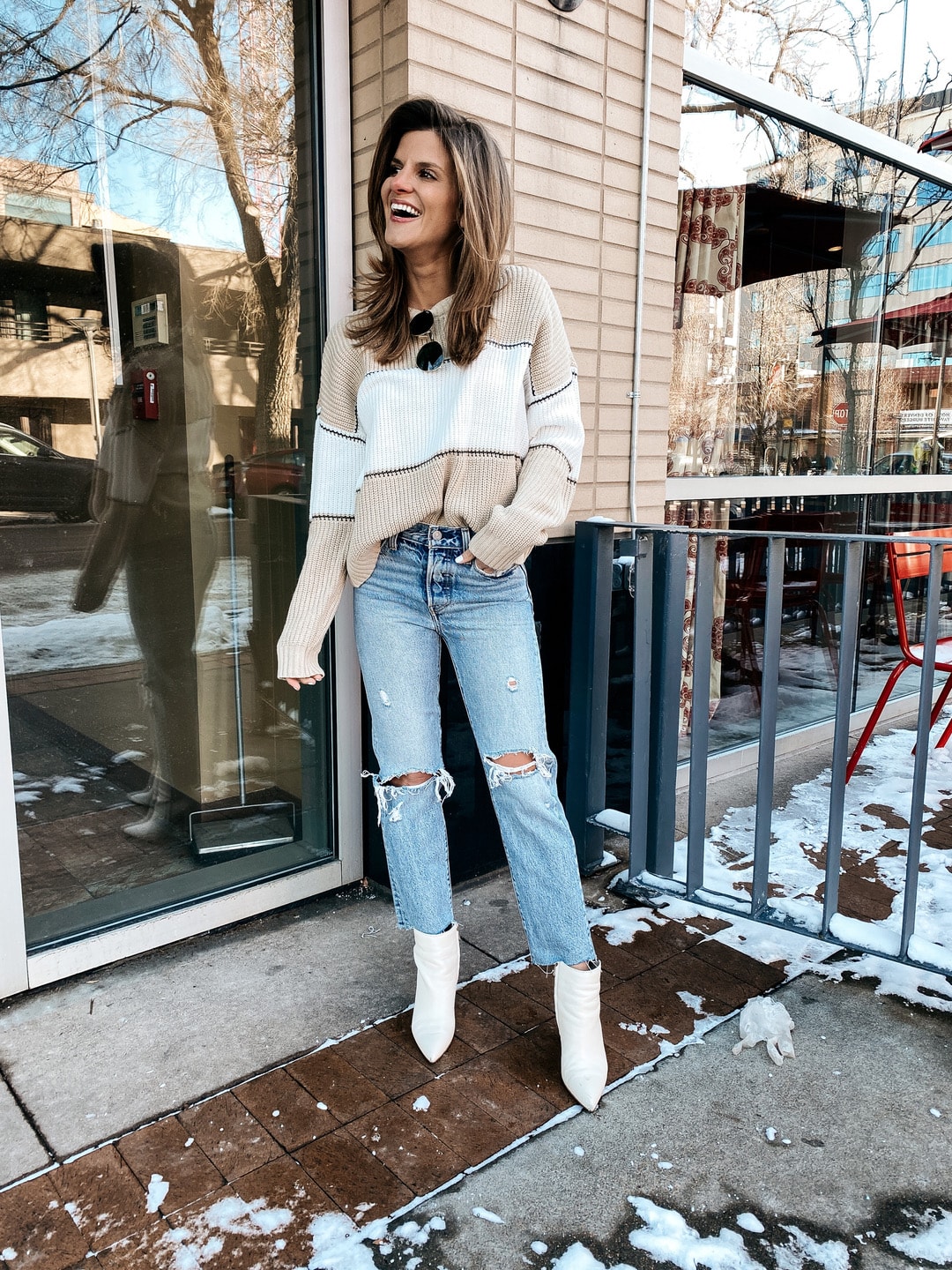 Brighton Keller wearing striped neutral sanctuary sweater, mom jeans and white booties