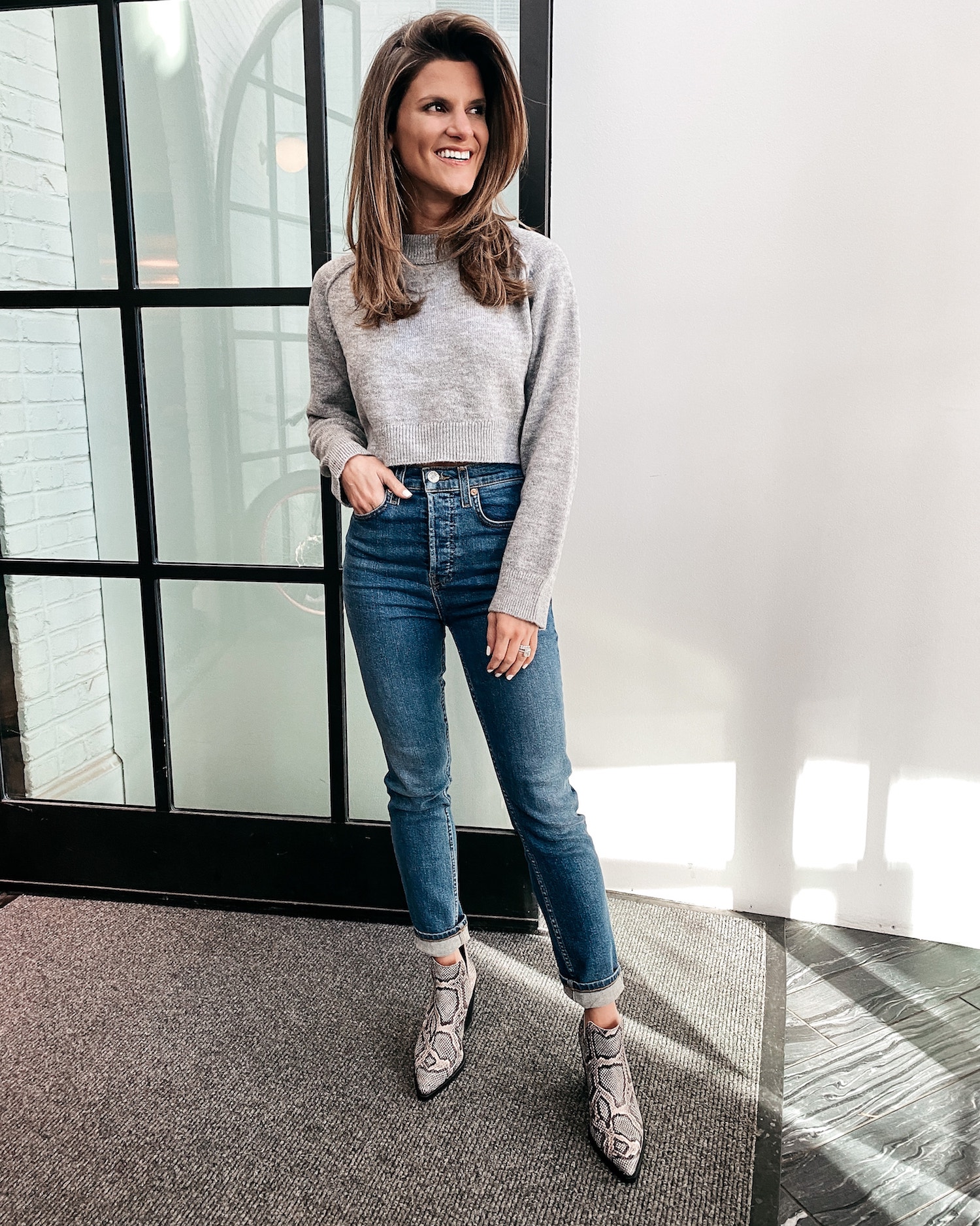 Brighton Keller wearing a cropped grey sweater, jeans and printed booties