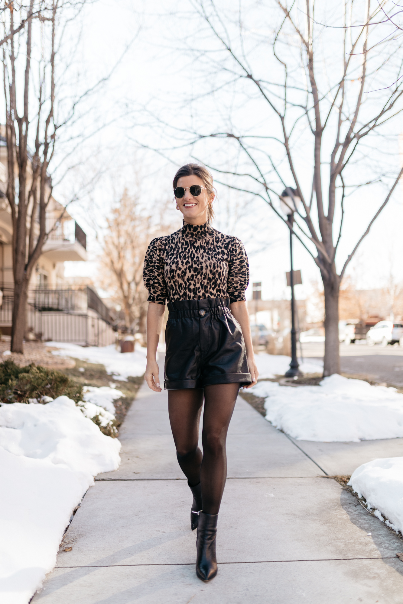 Brighton Keller wearing leopard puff sleeve short sleeve sweater and leather shorts