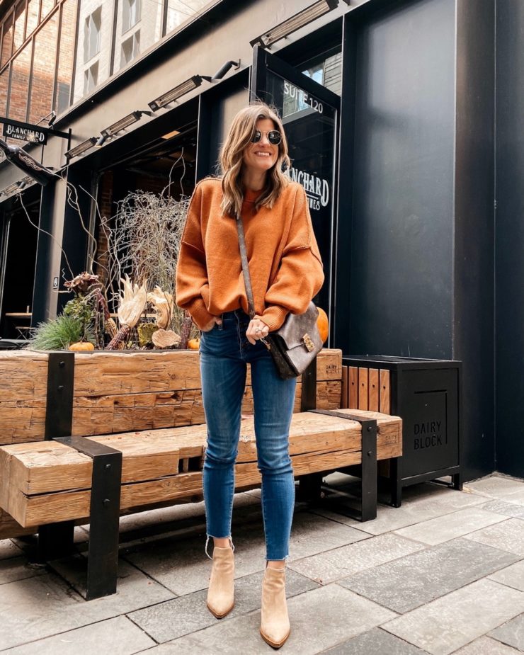 Brighton Butler wearing a free people orange tunic, jeans and tan booties