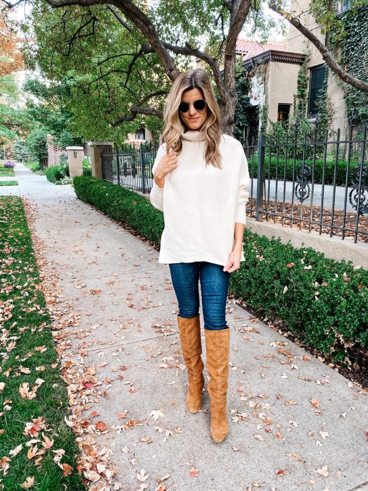 Brighton Butler wearing a white turtleneck tunic top, jeans and camel boots
