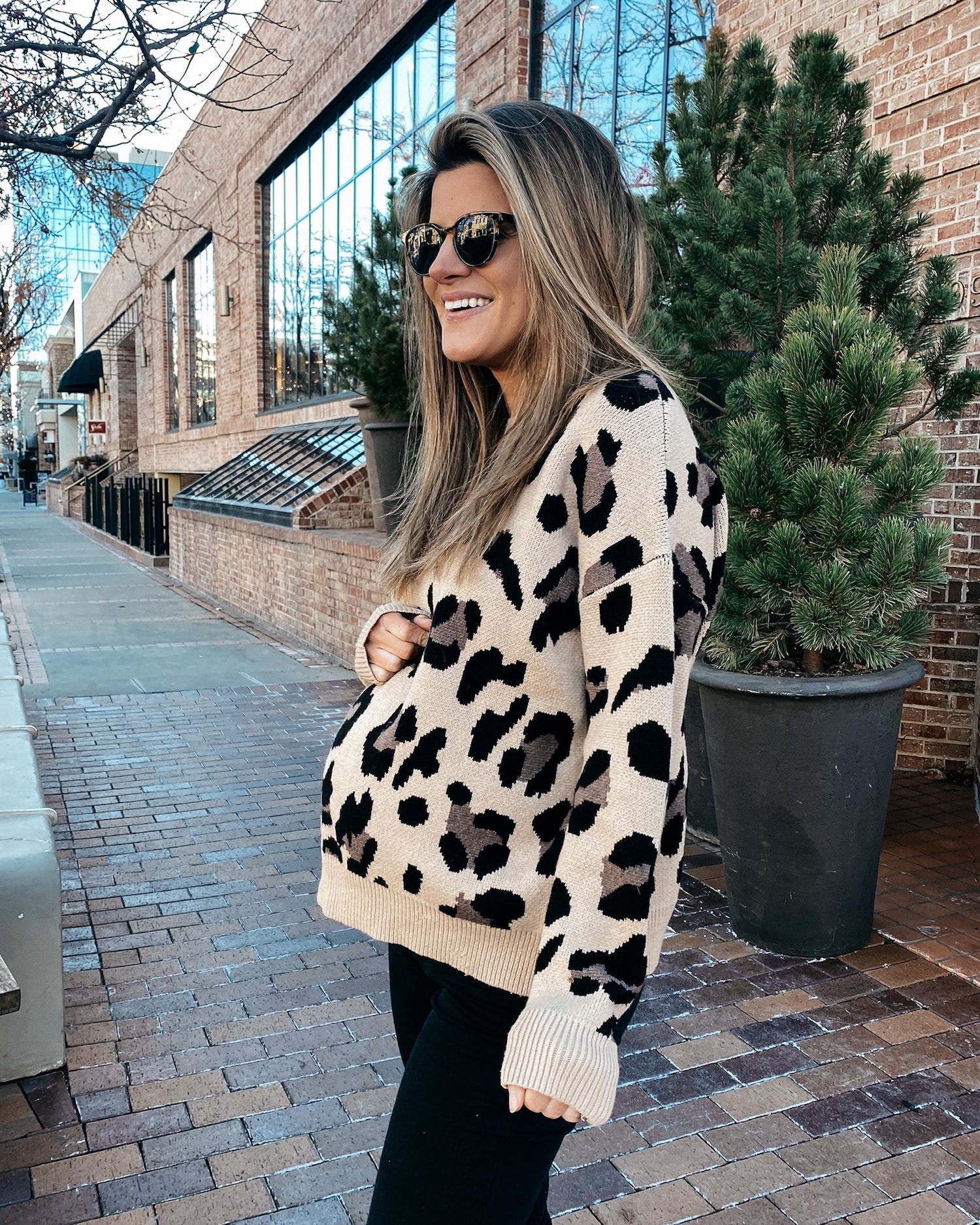 Brighton Butler in leopard sweater and black jeans, maternity fashion