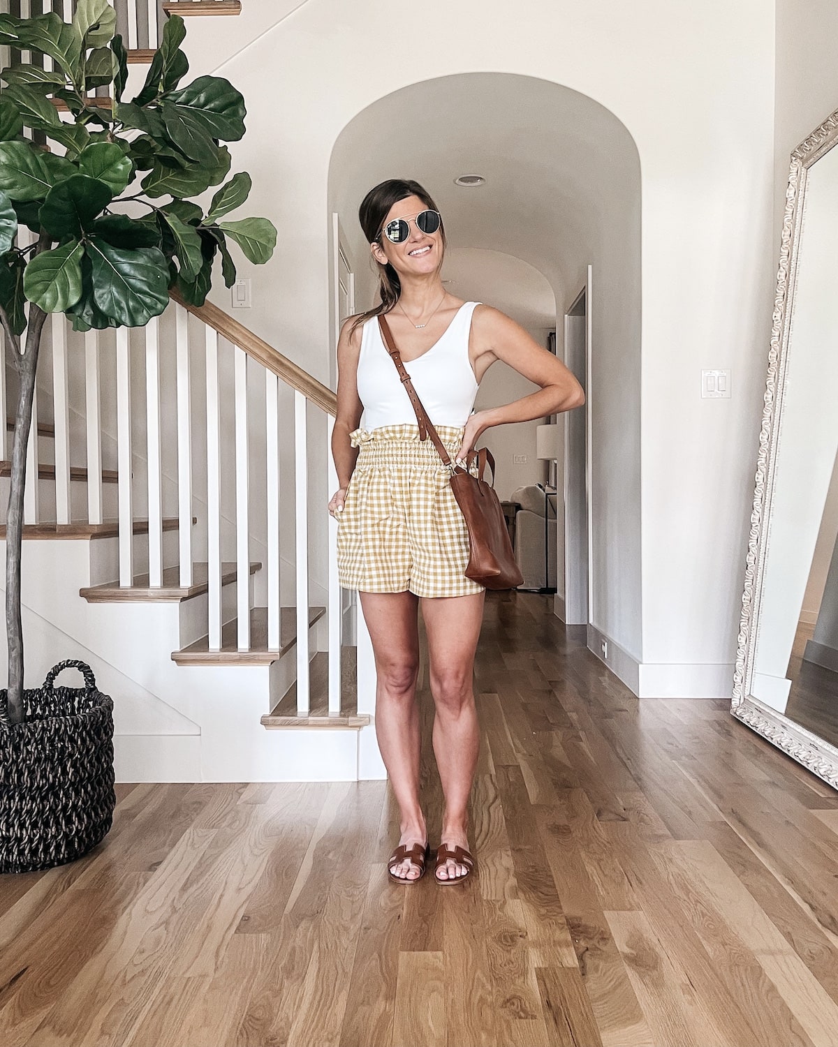 brighton butler wearing white body suit with gingham shorts