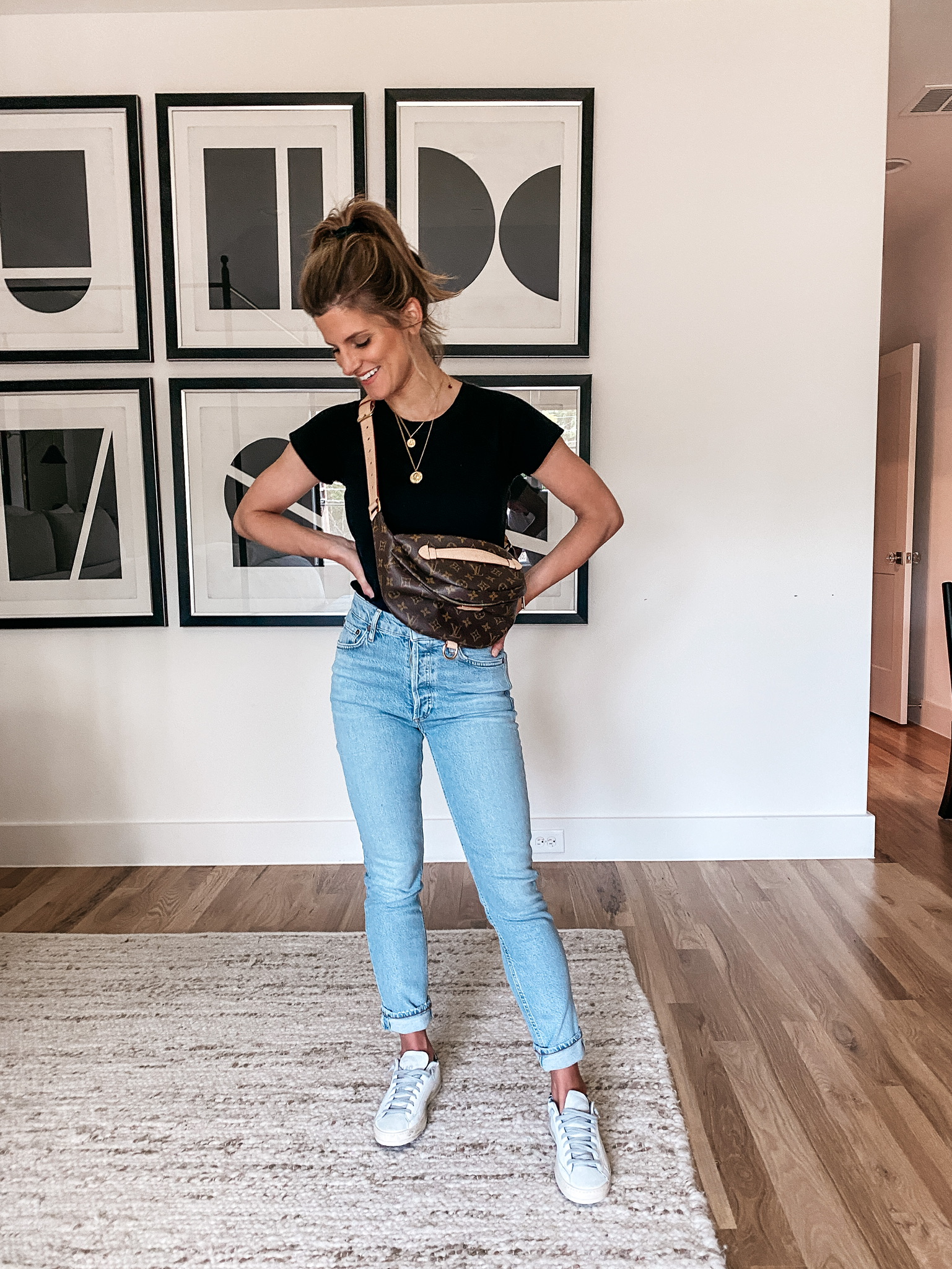 Brighton Butler wearing high rise straight jean, madewell black tee, and Louis Vuitton bag