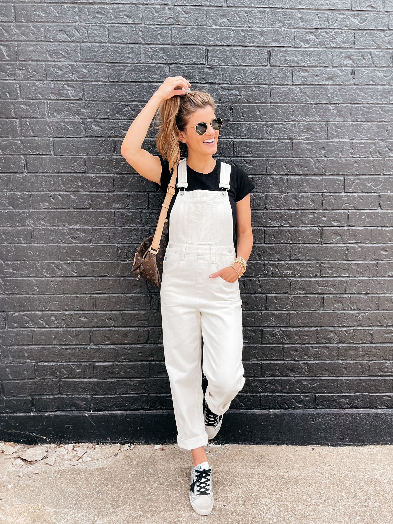 Brighton Butler wearing white overalls and black tee from madewell
