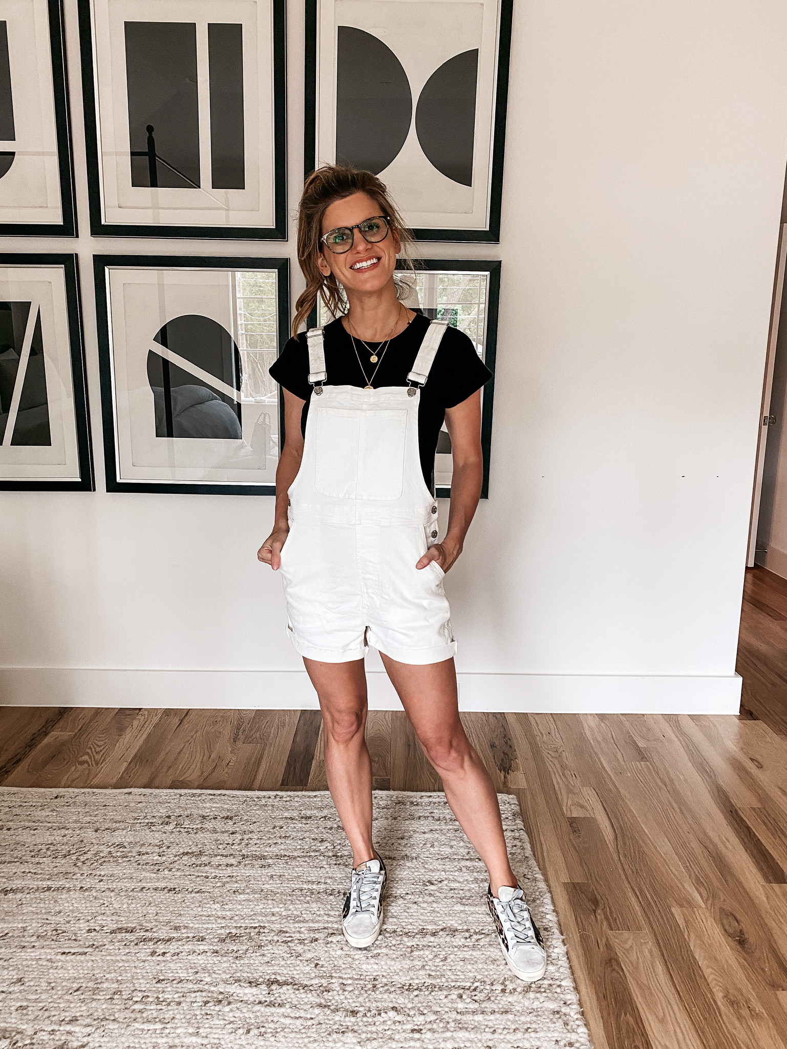 Brighton Butler wearing black tee and white overalls from madewell