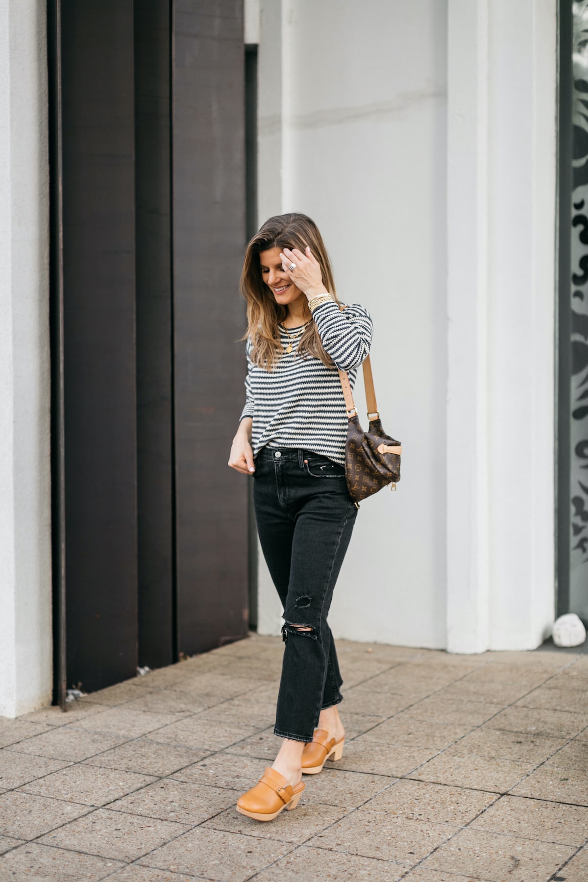 Brighton Butler wearing madewell clogs, striped sweater, black abercrombie jeans and bumbag