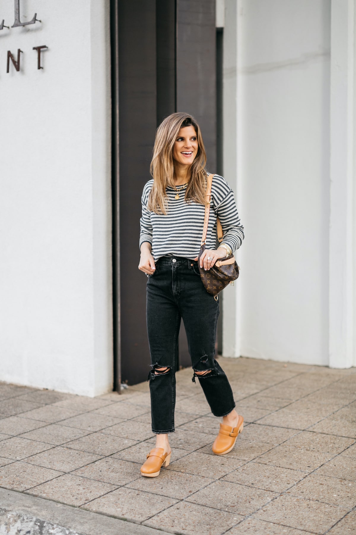 Brighton Butler wearing madewell clogs, striped sweater, black abercrombie jeans and bumbag