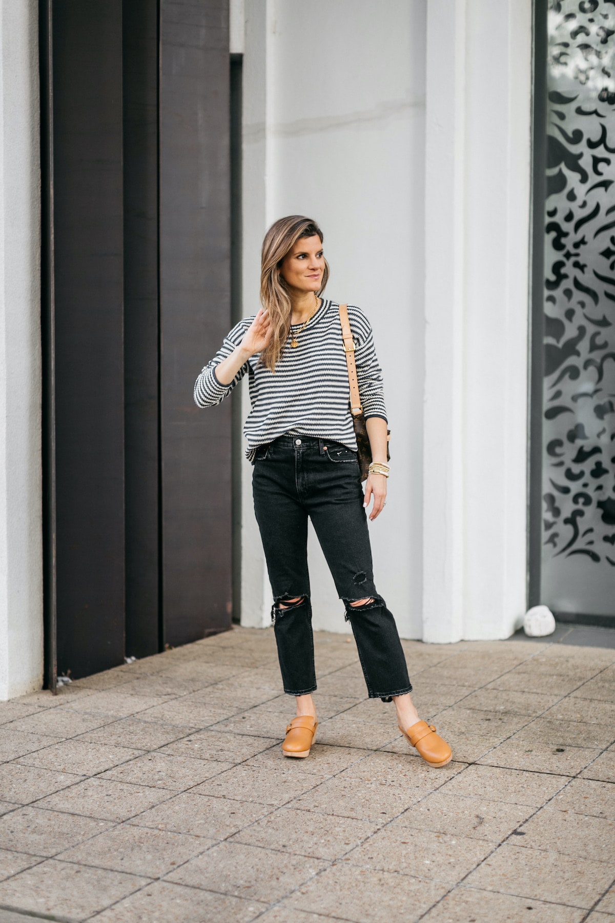 Brighton Butler wearing striped madewell sweater with black jeans, clogs and LV bumbag