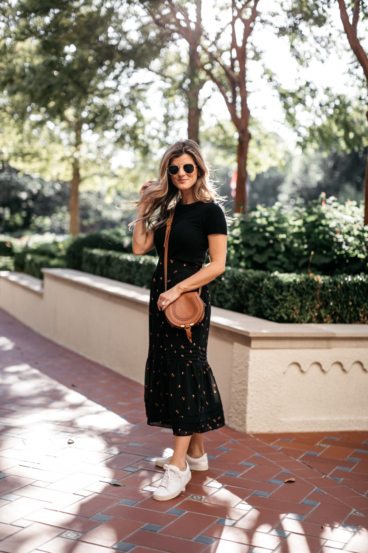 Brighton Butler wearing Madewell Fall Floral Skirt with Black tee and Frye white sneakers