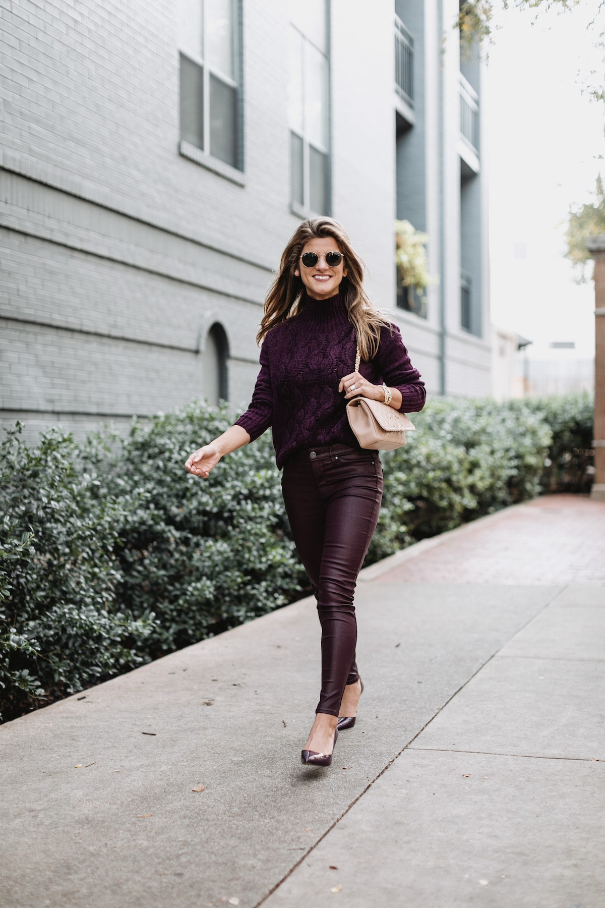 Brighton Butler wearing White House Black Market purple patent pants with purple sweater and pumps