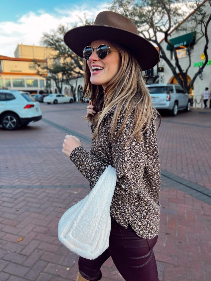 Brighton Butler wearing Stella Nova floral top with WHBM purple coated pants and sherpa purse