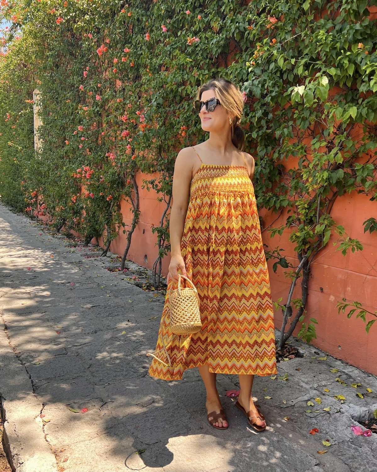 Brighton butler wearing orange and yellow dress with hermes sandals in san miguel sandal review